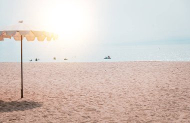 Güverte sandalyeleri ve tropik plajda beyaz şempanzeler. Yazın kumsalda beyaz şemsiye