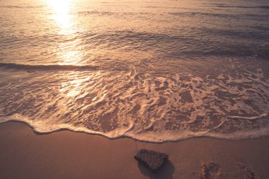 Yaz mevsiminde kumsalda yumuşak mavi dalgalar. Deniz plajı mavi gökyüzü ve güneş ışığı dinlenme manzarası. Suyun rengi ve güzel berrak su..