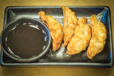 Seramik dikdörtgen şekilli siyah tabakta Çin usulü kızarmış hamur tatlısı. Çin geleneksel gıda sektörü hala hayat dolu