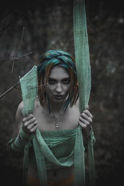 Sonbahar yeşili içinde yeşil ve sarı cüppeli ölü bir kız.