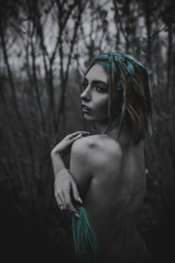 Sonbahar yeşili içinde yeşil ve sarı cüppeli ölü bir kız.