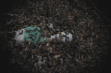 Sonbahar yeşili içinde yeşil ve sarı cüppeli ölü bir kız.