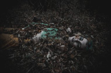 Sonbahar yeşili içinde yeşil ve sarı cüppeli ölü bir kız.