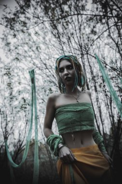 Sonbahar yeşili içinde yeşil ve sarı cüppeli ölü bir kız.