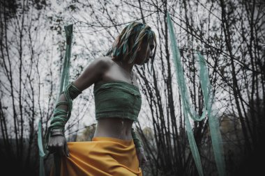 Sonbahar yeşili içinde yeşil ve sarı cüppeli ölü bir kız.