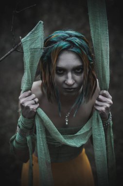 Sonbahar yeşili içinde yeşil ve sarı cüppeli ölü bir kız.