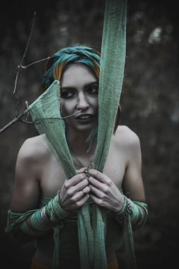 Sonbahar yeşili içinde yeşil ve sarı cüppeli ölü bir kız.