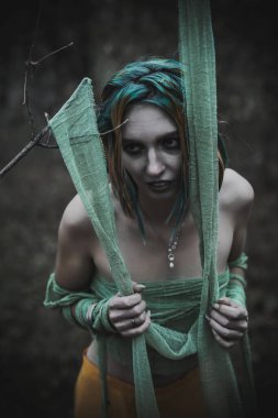 Sonbahar yeşili içinde yeşil ve sarı cüppeli ölü bir kız.