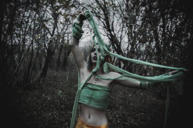 Sonbahar yeşili içinde yeşil ve sarı cüppeli ölü bir kız.