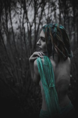 Sonbahar yeşili içinde yeşil ve sarı cüppeli ölü bir kız.