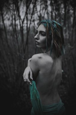 Sonbahar yeşili içinde yeşil ve sarı cüppeli ölü bir kız.