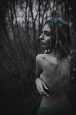 Sonbahar yeşili içinde yeşil ve sarı cüppeli ölü bir kız.