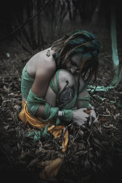 Sonbahar yeşili içinde yeşil ve sarı cüppeli ölü bir kız.