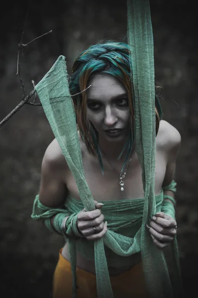 Sonbahar yeşili içinde yeşil ve sarı cüppeli ölü bir kız.