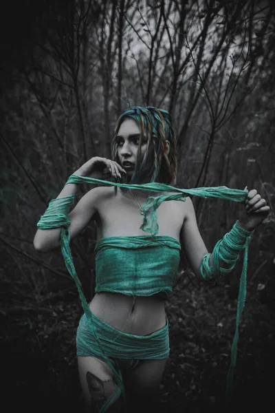 Sonbahar yeşili içinde yeşil ve sarı cüppeli ölü bir kız.