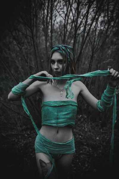 Sonbahar yeşili içinde yeşil ve sarı cüppeli ölü bir kız.