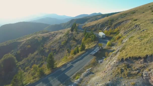 Vista aérea de grandes caminhões de carga que passam uns pelos outros na estrada da montanha sinuosa no dia ensolarado do outono na Bulgária — Vídeo de Stock