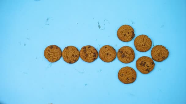 밝은 파란색 배경 배경에 화살표 모양을 형성하는 쿠키 스톱 모션 — 비디오
