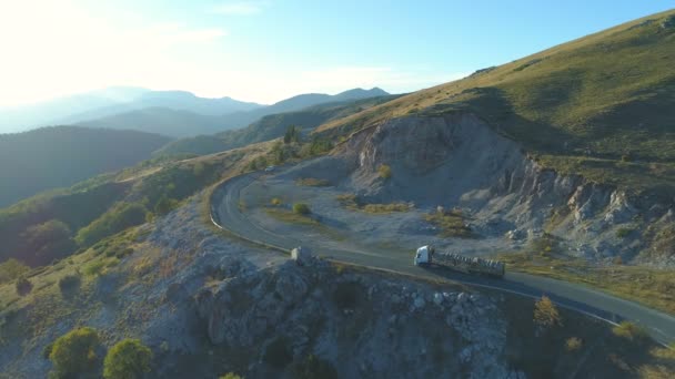 Luftaufnahme eines Holzlastwagens, der an einem sonnigen Tag in Bulgarien auf einer kurvenreichen Bergstraße fährt — Stockvideo