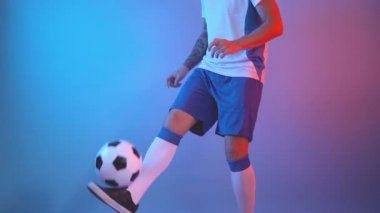 Serbest stil futbolcunun bacaklarıyla futbol topuyla hokkabazlık yapması, yakın çekim.