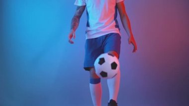 Serbest stil futbol ya da futsal oyuncusunun bacaklarıyla top oynaması ön planda.