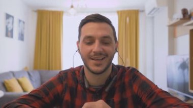 Mutlu genç adam evde çalışıyor ve karantina sırasında video görüşmesi yapıyor.