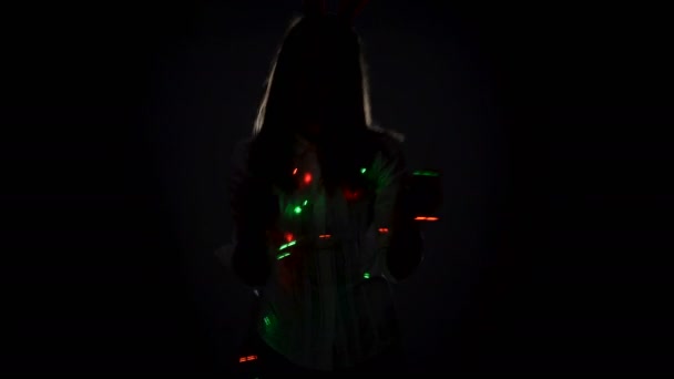 Karanlık bir odada Noel partisinde dans eden genç bir kadının silueti. — Stok video