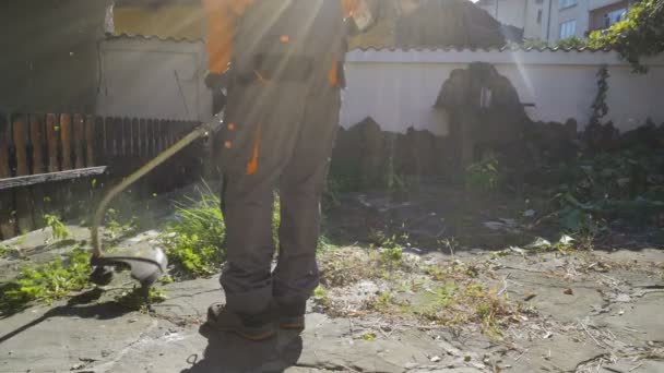 Jardim Paisagista homem cortando e cortando grama com máquina de corte de grama — Vídeo de Stock