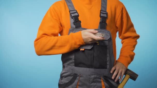 Unrecognizable repairman in industrial work clothes giving mock-up knife to the camera — Stock Video