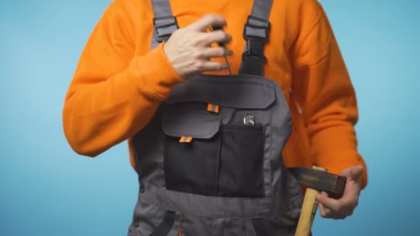 Handyman tar hammaren i fickan och ger skruvmejsel till kameran — Stockvideo