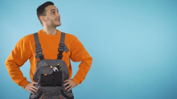 Smiling Construction worker looking to the side, presenting invisible product, copyspace — Stock Video