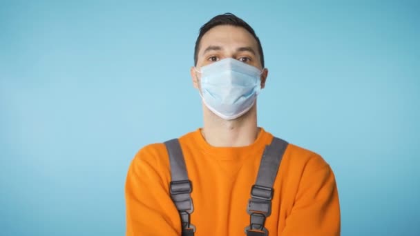 Male handyman or fixer fixing face mask and looking to the side — Stock Video