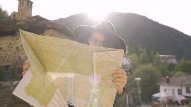 Genç, mutlu bir kadın, eski bir kasabada tatil yaparken haritayı keşfediyor.