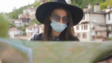 Tatillerde harita kullanarak tıbbi maskeli yeni normal turist
