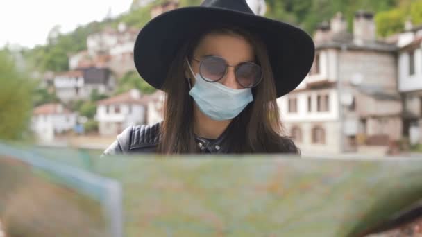 Ny normal turist med medicinsk mask i ansiktet med hjälp av karta under semestern — Stockvideo