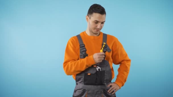 Confident repairman fixer handing off screwdriver, isolated on blue background — Stock Video