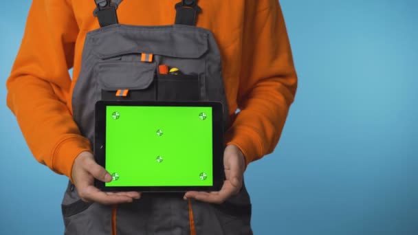 Close shot of construction worker hands holding a tablet with green screen. Commercial ready — Stock Video