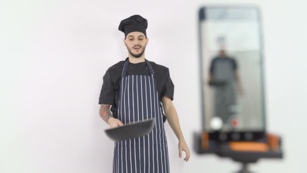 Mannelijke chef doet het houden van pan uit te leggen technieken aan studenten tijdens online les — Stockvideo