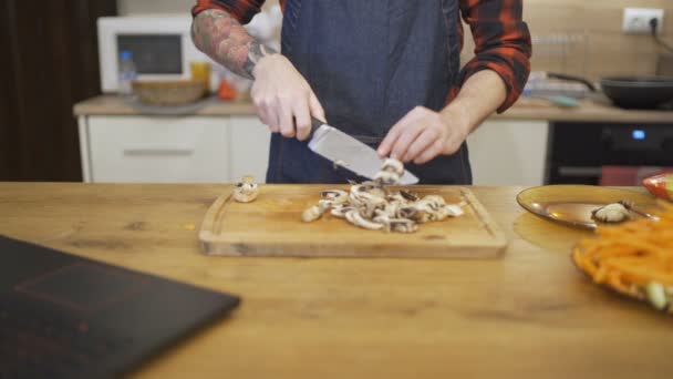 Giovane marito tagliando funghi preparare il Ringraziamento o pasto di Natale — Video Stock