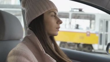 Şehir trafiğinde araba kullanan genç bir kadın sürücü