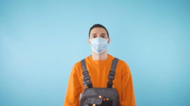 Yüz maskeli ciddi görünümlü bir tamircinin profil görüntüsü