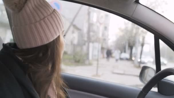 Fiatal női sofőr várja a forgalmat a város kereszteződésénél — Stock videók