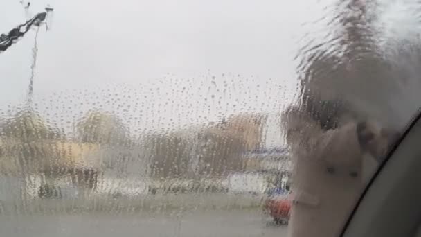 Mujer lavando su ventana delantera del coche con chorro de agua de alta presión — Vídeo de stock