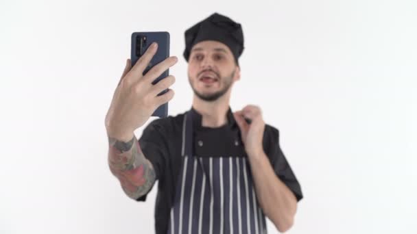 Chef en uniforme haciendo videollamada o clase en línea en el teléfono inteligente sosteniéndolo en la mano — Vídeo de stock