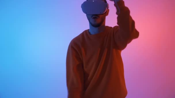 Jonge gamer het dragen van virtual reality bril voor gaming toepassingen, met behulp van controllers zoals zwaarden — Stockvideo