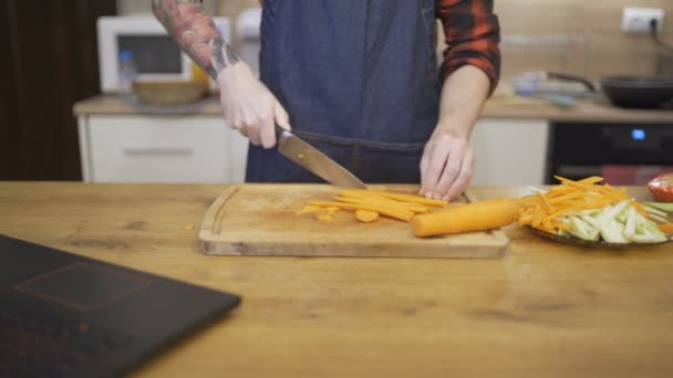 Giovane in grembiule che taglia carote per la cena di Natale — Video Stock