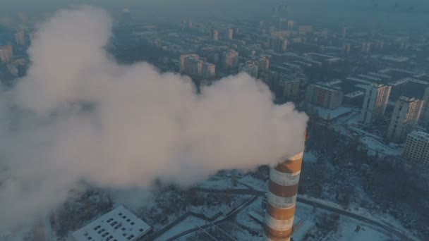 Luchtfoto van hoge schoorsteenpijpen met grijze rook met stad op de achtergrond — Stockvideo