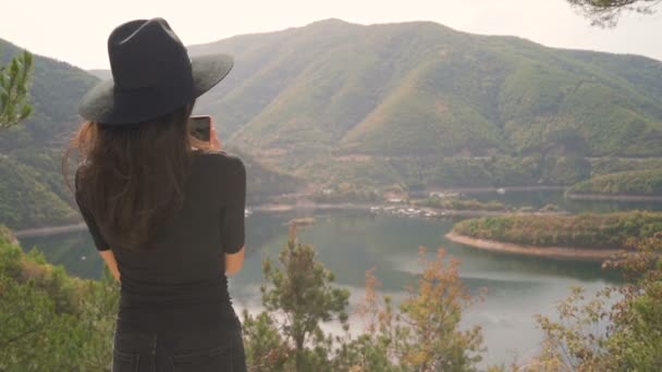 Jovem mulher tirando fotos de lago de montanha — Vídeo de Stock