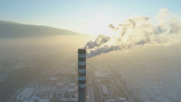 Drone survolant les cheminées fumantes d'une usine. Pollution atmosphérique. Nuages de fumée provenant des cheminées au coucher du soleil — Video