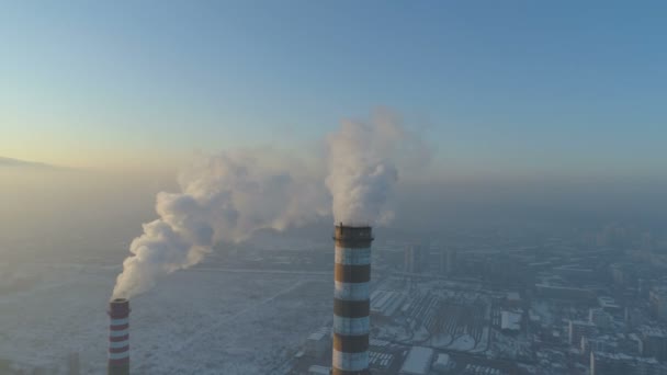 Red and white factory chimneys smoking dense white smoke above city — 비디오